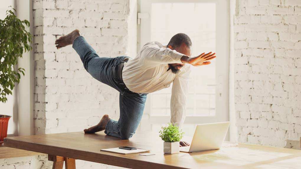 Mann beweist sein Durchhaltevermögen durch Yogaübungen bei der Arbeit